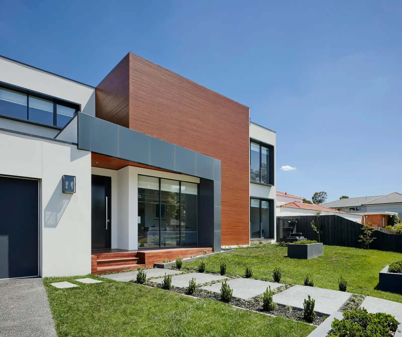 A contemporary home with a landscaped lawn and stepping-stone path