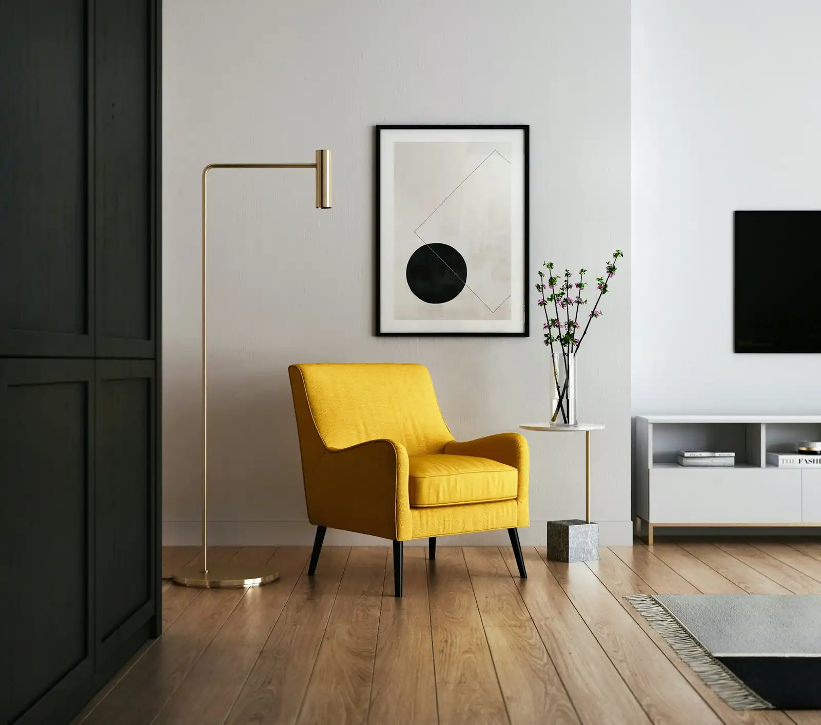 A styled interior corner with a yellow armchair, floor lamp and framed artwork