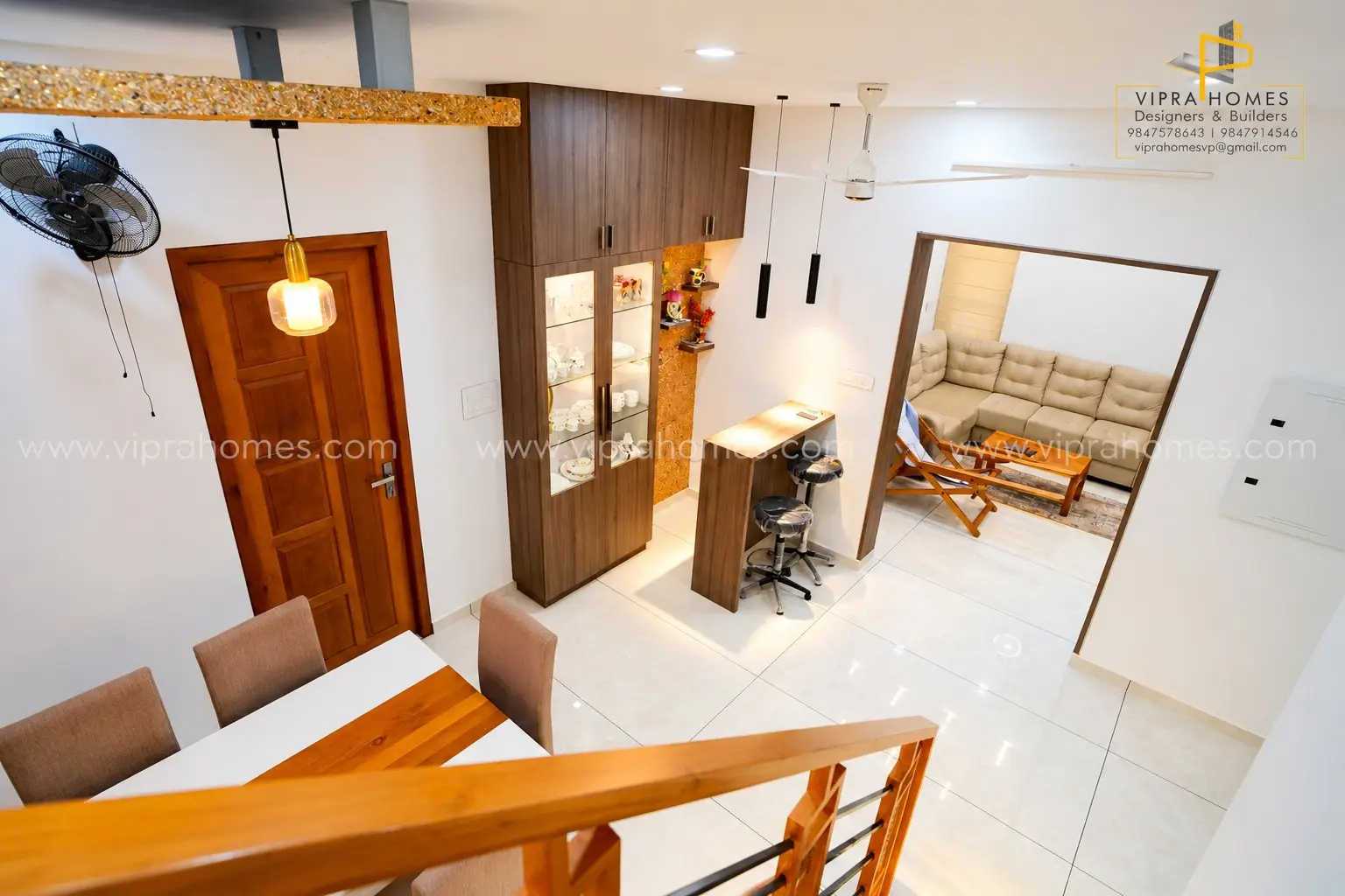 Dining and crockery area by VIPRA HOMES with a timber cabinet, breakfast counter and pendant lights